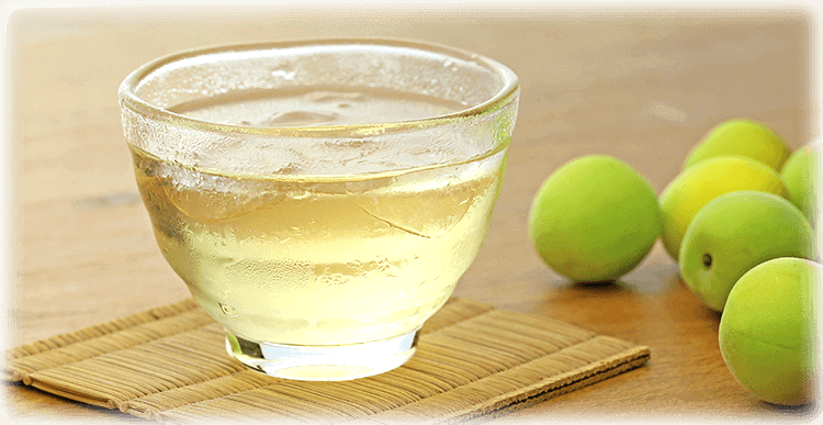 琥珀色の梅酒をコップに注いだイメージ